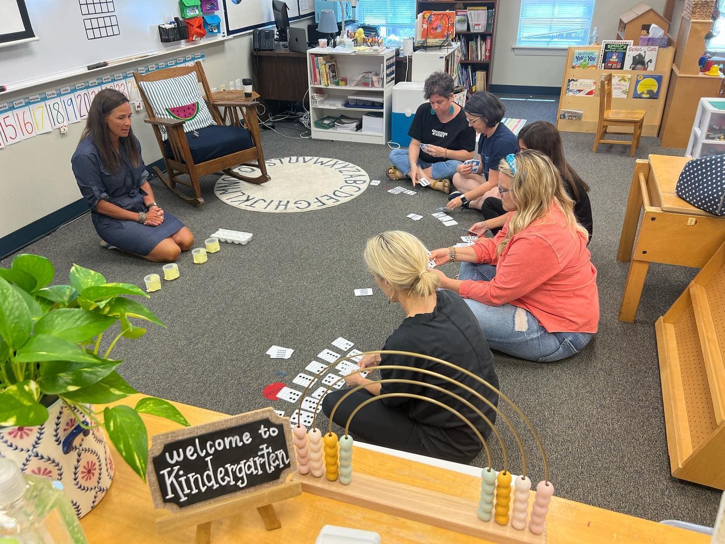 Teachers sitting together on the floor, learning how to teach math a new way.