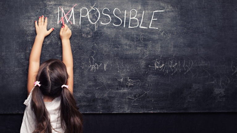 Child reaching up on a chalkboard