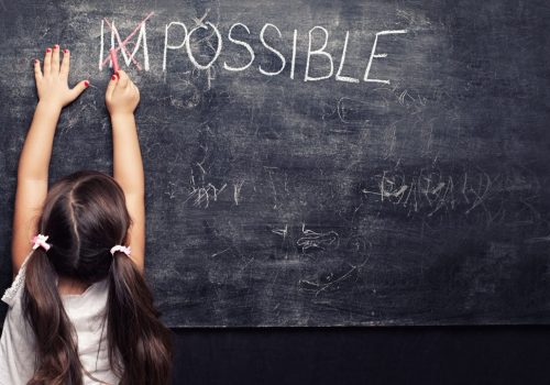Child reaching up on a chalkboard